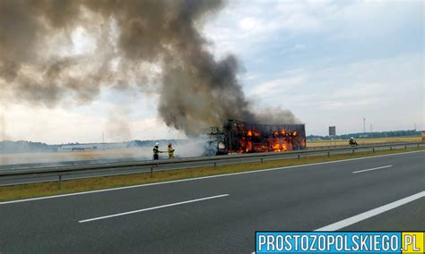 Policjanci gaszący pożar ciężarówki na autostradzie A4, obok pola uprawne