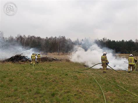 Strażacy gaszący pożar trawy w terenie otwartym