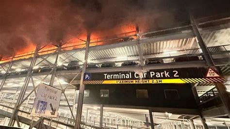 Thematic photo of fire in a multi-story car park, black smoke over an industrial area