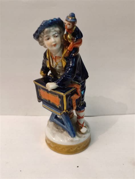 Antyczna porcelanowa figurka strażaka o wysokości 10 cm, oznaczona zielonym znakiem Puls porcelany