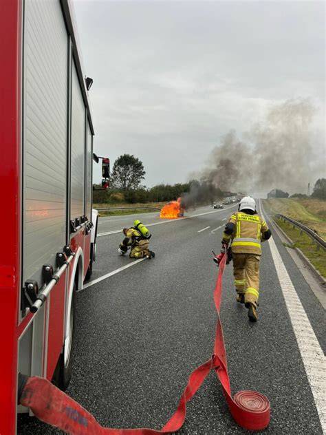 Zdjęcie płonącego samochodu osobowego na drodze publicznej