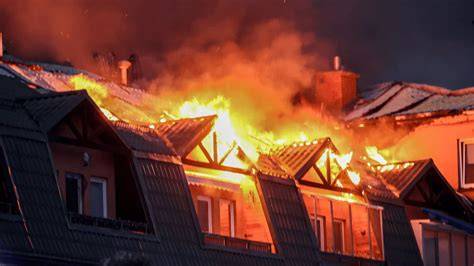 Zdjęcie strażaków gaszących pożar w miejskiej zabudowie