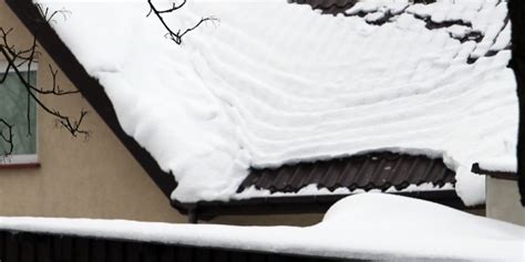 Zdjęcie przedstawiające ciężki śnieg zalegający na dachu budynku