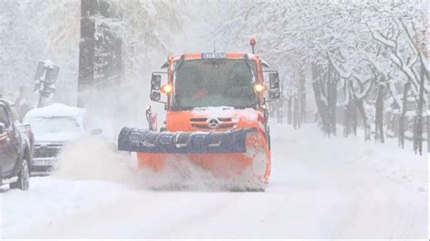 Zdjęcie przedstawiające pługopiaskarkę pracującą na ulicy w Gdańsku podczas opadów śniegu