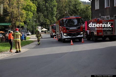 Akcja ratunkowa strażaków podczas pożaru mieszkania w Brodach, z widocznym dymem i pojazdami ratowniczymi