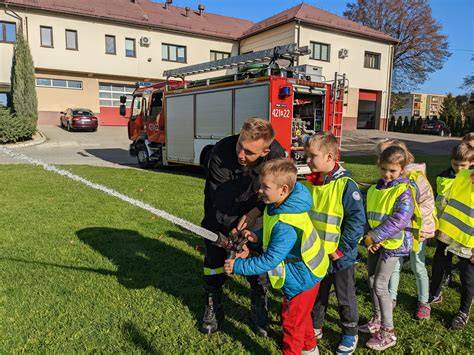 Grupa przedszkolaków w remizie strażackiej, oglądająca wóz strażacki