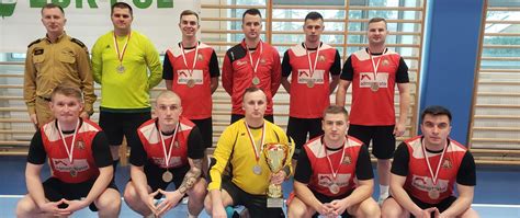 Zdjęcie przedstawiające drużyny strażaków podczas rozgrywek sportowych w hali