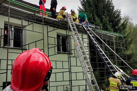 Tematyczne zdjęcie kominiarza przy pracy na dachu i strażaków podczas interwencji