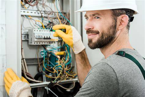 Tematyczne zdjęcie przedstawiające elektromontera podczas pracy z instalacją elektryczną w budynku