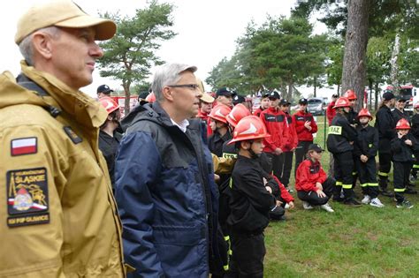 Młodzi strażacy podczas obozu szkoleniowego, zapoznający się ze sprzętem gaśniczym