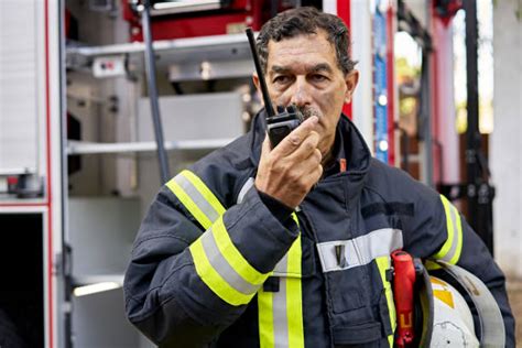 Thematic photo of a firefighter using a handheld radio in action