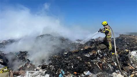 Pożar wysypiska śmieci w nocy z widocznymi płomieniami i gęstym dymem