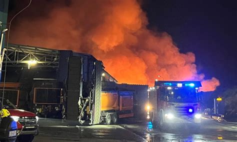 Widok na płonącą halę sortowni odpadów w Elblągu nocą, unoszący się dym