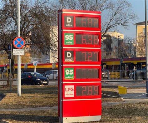 Zgromadzenie protestujących kierowców na stacji paliw, transparenty z hasłami o cenach paliw