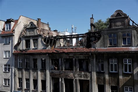 Zdjęcie spalonej elewacji kamienicy z widocznymi śladami ognia na balkonie i oknach