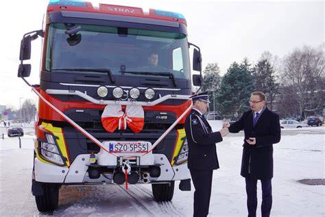 Strażacy odbierają symboliczne kluczyki do nowego wozu strażackiego
