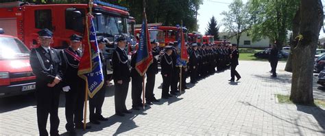 Grupa strażaków w mundurach, sztandary jednostek OSP, goście honorowi podczas uroczystości