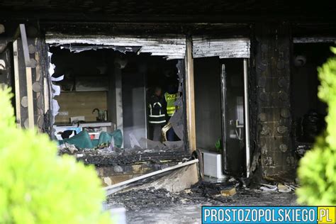 Zdjęcie miejsca pożaru z widocznymi zniszczeniami i akcją strażacką