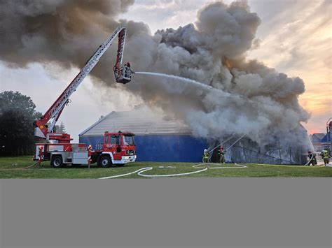 zdjęcie płonącej hali z wyrobami drewnianymi w Raciborzu, widoczne płomienie i działania strażaków