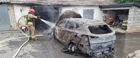 Zdjęcie płonącego samochodu osobowego i tlących się elementów garażu