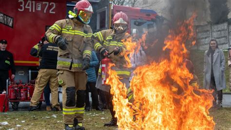 Uczestnicy szkolenia przeciwpożarowego dla dzieci, pokazujący jak gasić mały pożar