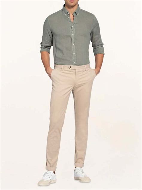 Młody mężczyzna w restauracji, ubrany w stylizacji smart casual: chinosy, koszula i lekka marynarka.