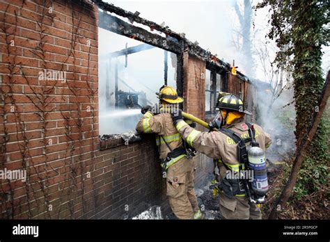 Thematic photo of firefighters extinguishing a house fire at night