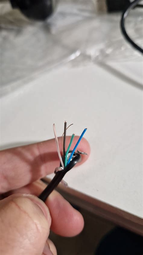 Zdjęcie uszkodzonego kabla USB z widocznymi przewodami