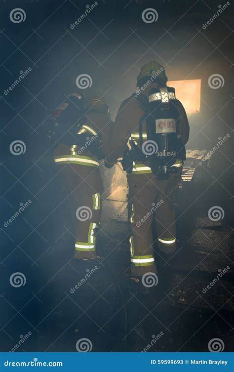 Photo of firefighters in breathing apparatus working inside a smoke-filled building
