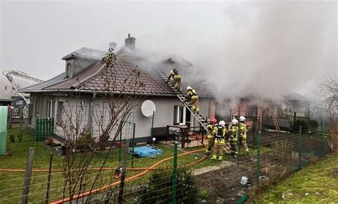 Strażacy gaszący płonący dach budynku wielorodzinnego w Linkach