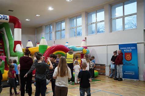 Dzieci bawiące się na dmuchańcach i animacjach podczas festynu