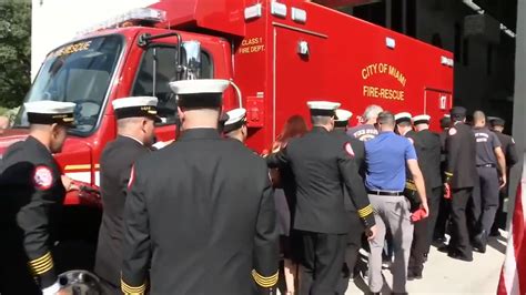 Thematic photo of firefighters and a new fire truck during a ceremony with local community and officials.