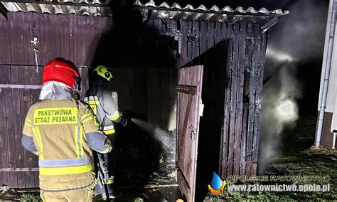 Zdjęcie przedstawiające pożar drewnianej szopy w Kupnie, z widocznymi strażakami w akcji