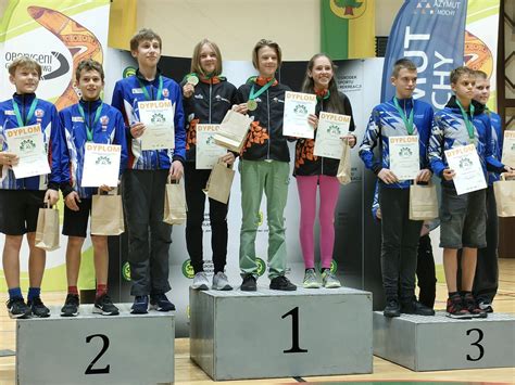 Zdjęcie przedstawiające trzech nagrodzonych zawodników z ich trofeami i dyplomami