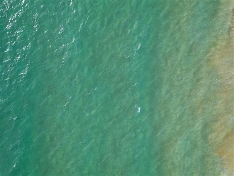 Widok z lotu ptaka na płonącą halę magazynową z makulaturą, otoczoną przez wozy strażackie.