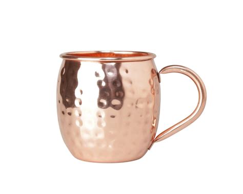 Zestaw składników do Moscow Mule: butelka wódki, świeże limonki, butelka piwa imbirowego i miedziany kubek.