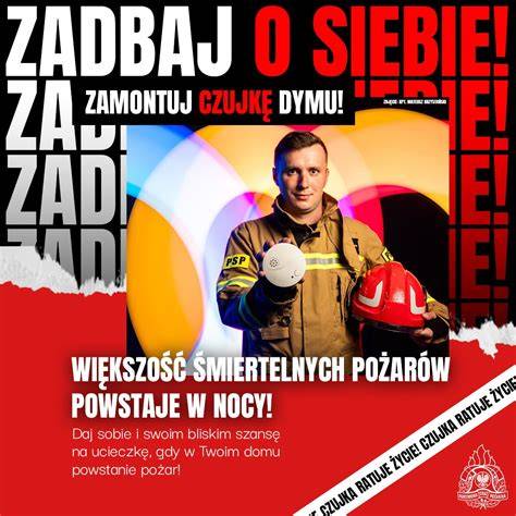 Ilustracja przedstawiająca Strażaka Sama w hełmie i uniformie strażackim, z wozem strażackim Jupiter w tle, gotowego do akcji