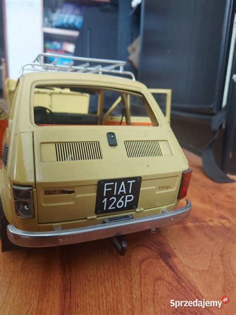 Zrzut ekranu z gry prezentujący model Fiata 126p w otoczeniu wirtualnego miasta