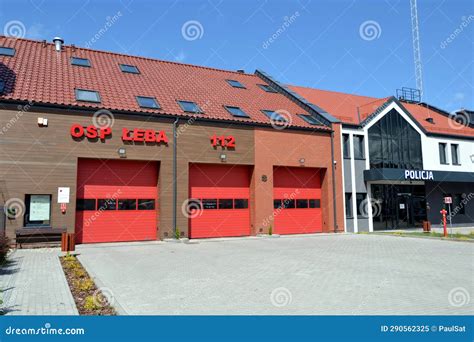The building of a small, local fire station (OSP) with a fire truck in front, in a rural setting, possibly in Poland