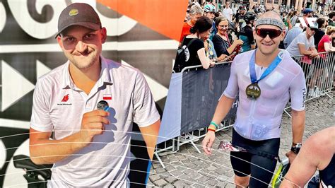 Maciej Wiśniewski podczas zawodów triathlonowych na tle mety
