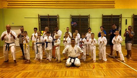 Zdjęcie przedstawiające halę sportową podczas zawodów karate z widocznymi matami i zawodnikami w kimonach