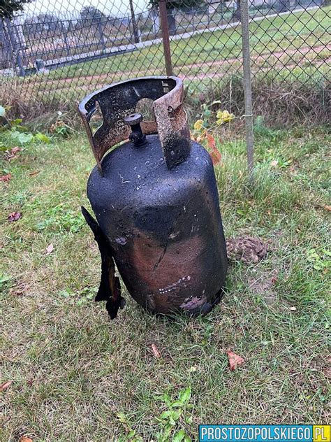 zdjęcie zniszczonej przyczepy kempingowej, obok której widać pozostałości po butli z gazem