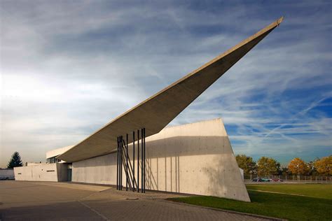 Zdjęcie Remizy strażackiej Vitra w Weil am Rhein prezentujące jej dynamiczną, ostrą bryłę i betonowe płaszczyzny
