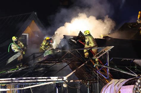 strażacy pracujący na dachu płonącej restauracji