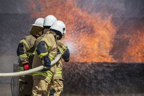 Thematic photo of firefighters extinguishing a fire in an industrial area at dawn