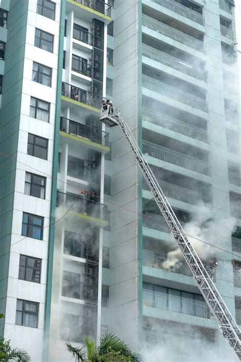 Thematic photo of firefighters extinguishing a fire in a residential building, with visible smoke in the stairwell.