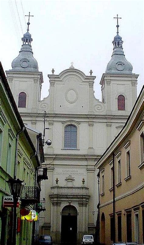 Zdjęcie fasady kościoła jezuitów w Kaliszu z pomnikami na dziedzińcu
