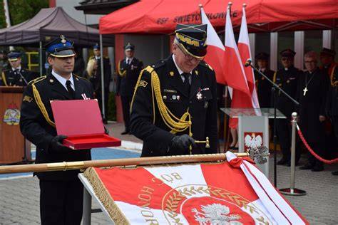 Sponsorzy oraz członkowie OSP Brodno podczas ceremonii wbijania gwoździ w sztandar