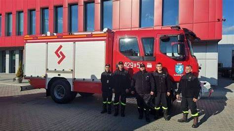 Samochód bojowy OSP Szachy stojący przed nowo wybudowanym garażem