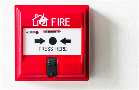 Thematic photo of a Legrand fire safety button with an emergency situation in the background